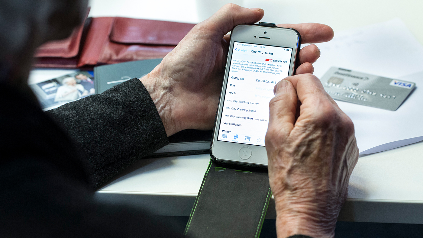 Ein Senior hält sein Ipad in den Händen und liest.